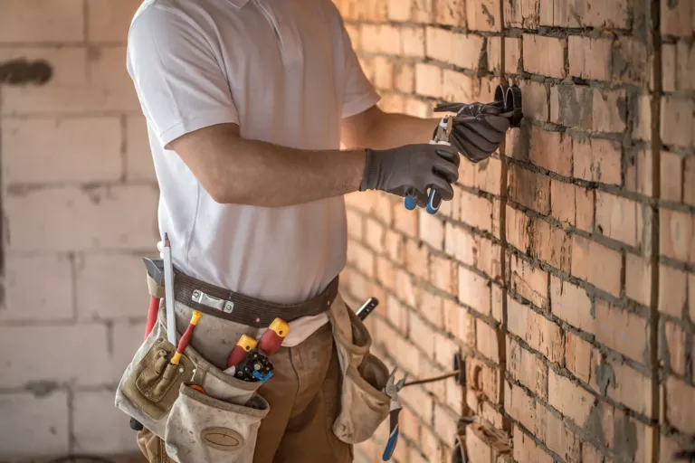 Hombre trabajando pared de ladrillos.